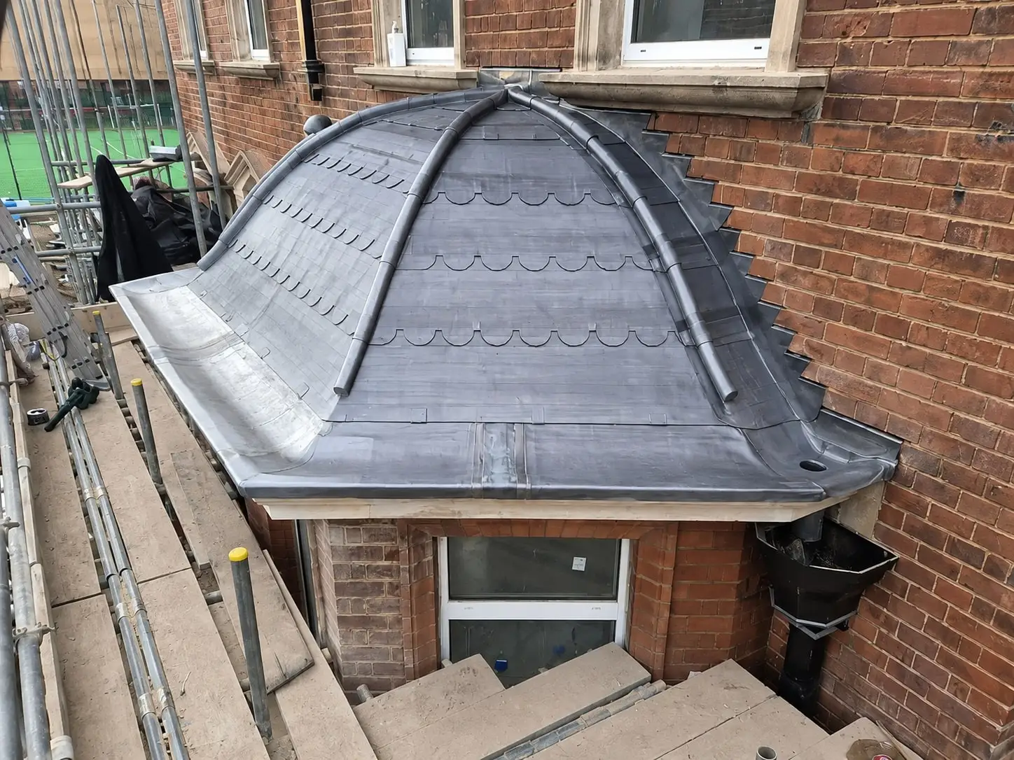 Close view of hand-dressed lead rolls on a domed bay roof