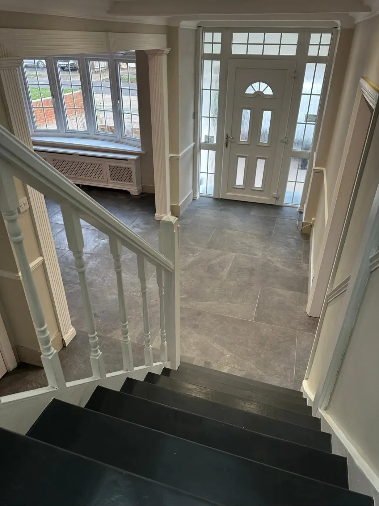 Refurbished hallway with new floor tiles, staircase and fresh decoration