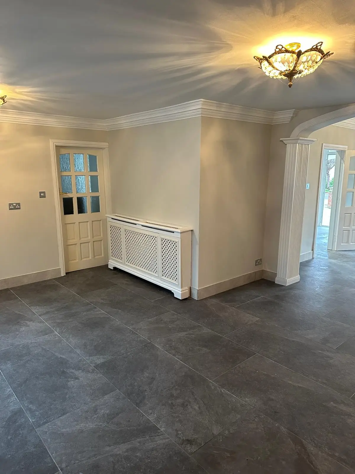 Reception room with radiator cabinet and glazed door after refurbishment