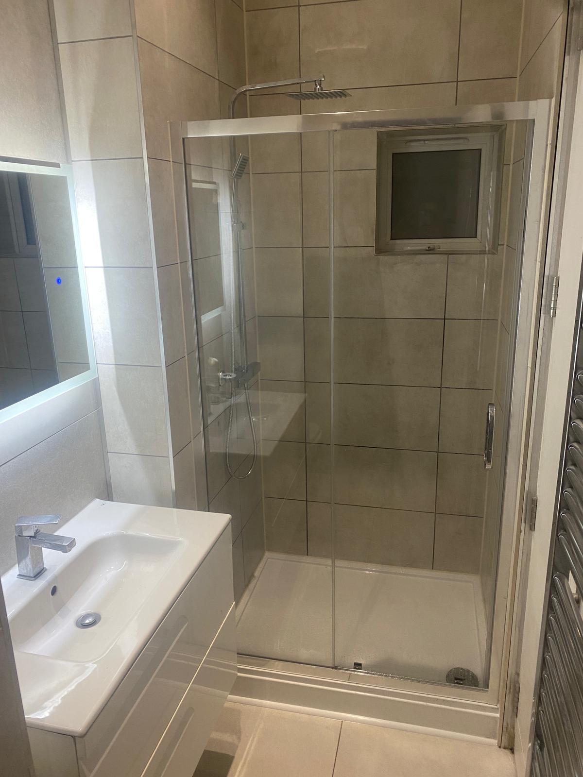 Newly refurbished bathroom featuring a glass shower eNewly refurbished bathroom featuring a glass shower enclosure and tiled walls by SwiftFix Londonnclosure and tiled walls by SwiftFix London.
