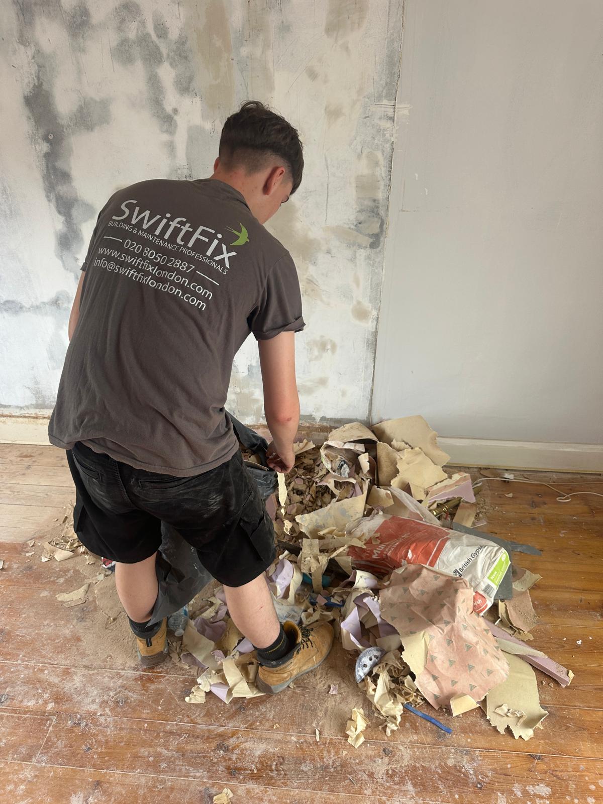 SwiftFix London worker performing demolition work indoors.