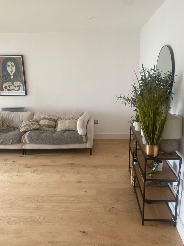 Modern living room renovation by SwiftFix London featuring beige sofa, wooden flooring, and minimalist decor.