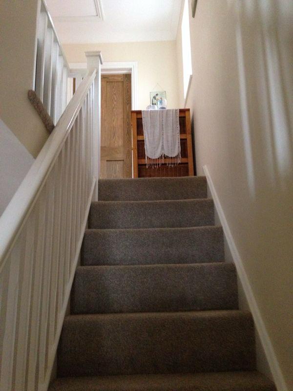 Home renovation by SwiftFix London showing carpeted staircase with white banister and hallway in Haringey.