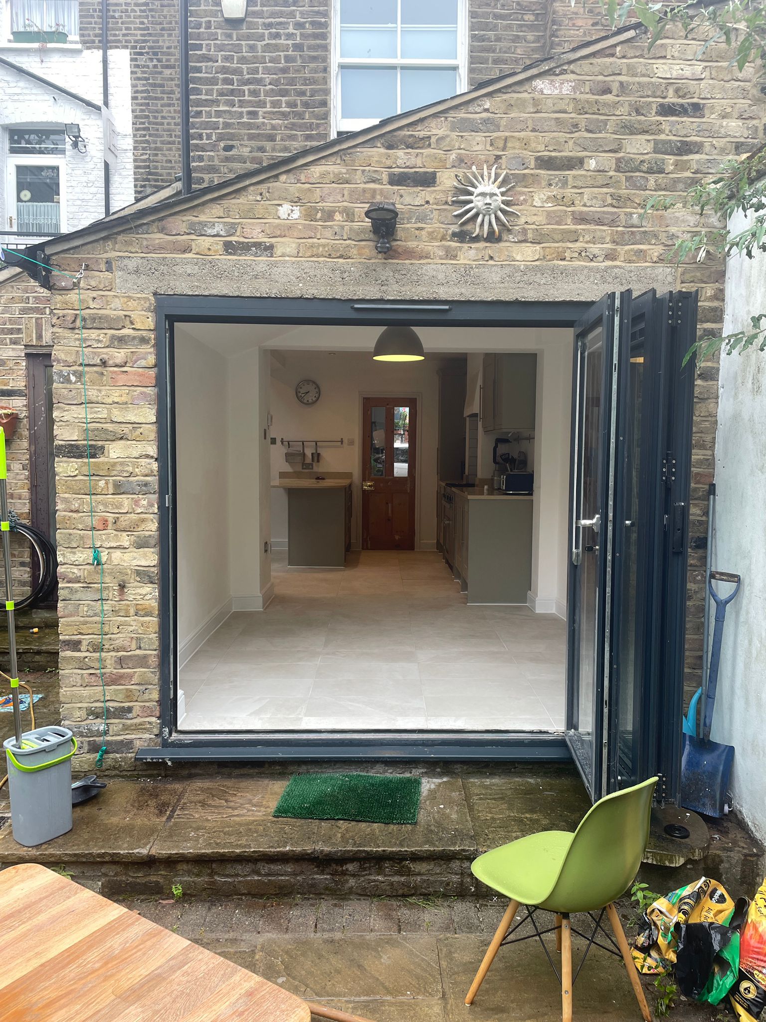 Home extension with bifold doors opening to a modern kitchen by SwiftFix London.